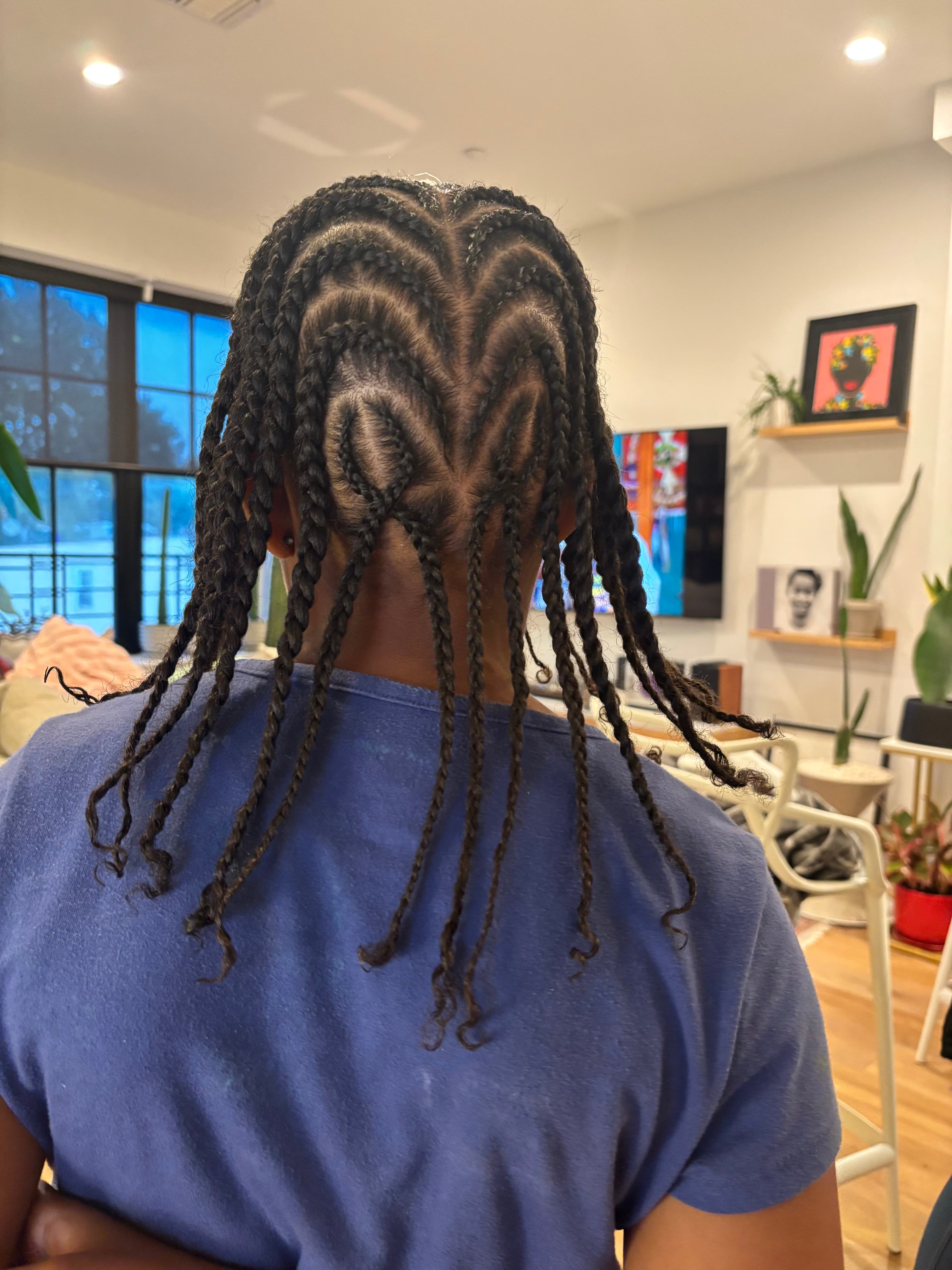 Detailed cornrow hairstyle with curved heart-shaped braid patterns